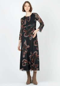 Schwarzes Kleid mit langen, durchsichtigen Ärmeln und floralem Muster in Rot- undTürkis-Tönen. Mit einer geknoteten Taillendetail und fließendem Saum.