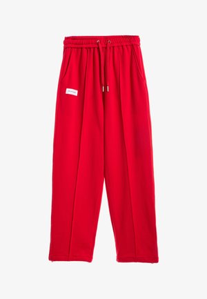 Pantalones casuales de color rojo brillante con cintura elástica, cordón, bolsillos laterales y una pequeña etiqueta rectangular blanca en el muslo izquierdo.