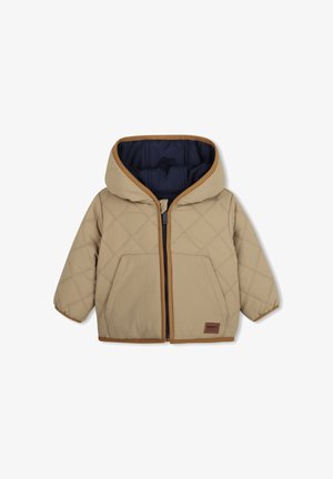 Veste matelassée beige pour tout-petit avec capuche, fermeture éclair devant, deux poches et bordure marron, doublée de tissu bleu marine foncé à l'intérieur.