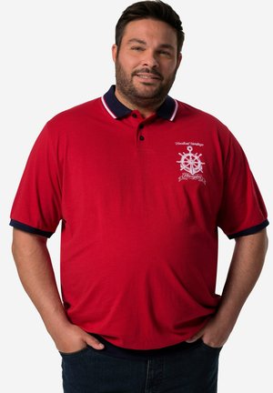 Punainen polo paita, jossa on tummansiniset kaulus ja hihansuut, ja jossa on valkoinen brodeerattu ankkurimuotoilu. Valmistettu pehmeästä, hengittävästä kankaasta.