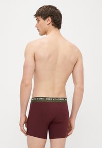 Bordowe bokserki z miękką fakturą, elastycznym zielonym pasem z logo "ONLY & SONS". Widoczne szwy i dopasowany fason.