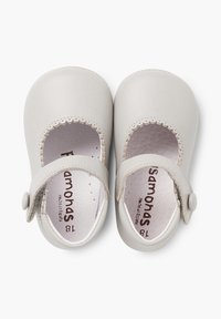 Zapatos Mary Jane de cuero gris con borde en forma de ondas, correa ajustable y cierre de botón. Forro interior suave, suelas planas.