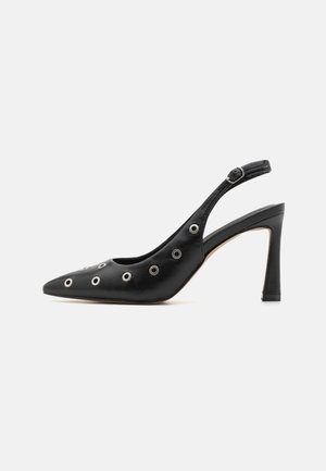 Escarpin en cuir noir à dos ouvert avec un nez pointu, détails en œillets métalliques et un talon aiguille haut. Texture lisse, design minimaliste.