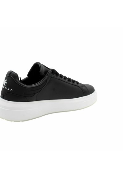 Sneaker in pelle nera con una finitura liscia, caratterizzata da un design con lacci, punta rotonda, suola spessa bianca e dettaglio del logo sul tallone.