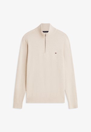 Pull beige à manches longues avec col à demi-fermeture éclair et petit logo drapeau Tommy Hilfiger sur la poitrine gauche.