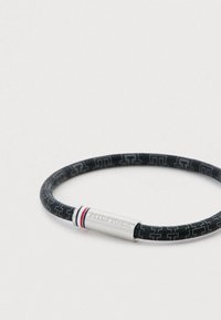 Μαύρο λαστιχένιο βραχιόλι με σχέδιο από διαπλεκόμενα λογότυπα "H", με απολήξεις από ασημί κυλινδρικό κούμπωμα με κόκκινες και μπλε λεπτομέρειες.