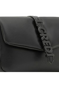 Zwarte leren schoudertas met een klepluiting en een gestructureerd oppervlak; voorzien van gedurfde, reliëflettering hardware.