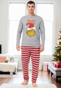 Maglietta da pigiama grigia a maniche lunghe con stampa del Grinch; pantaloni da pigiama a righe rosse e grigie; materiale in cotone; vestibilità comoda.