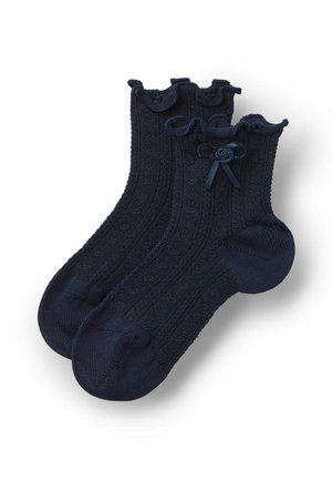 Calzini alla caviglia blu navy con motivo a maglia strutturato, polsini arricciati e piccolo fiocco decorativo su ogni polsino.