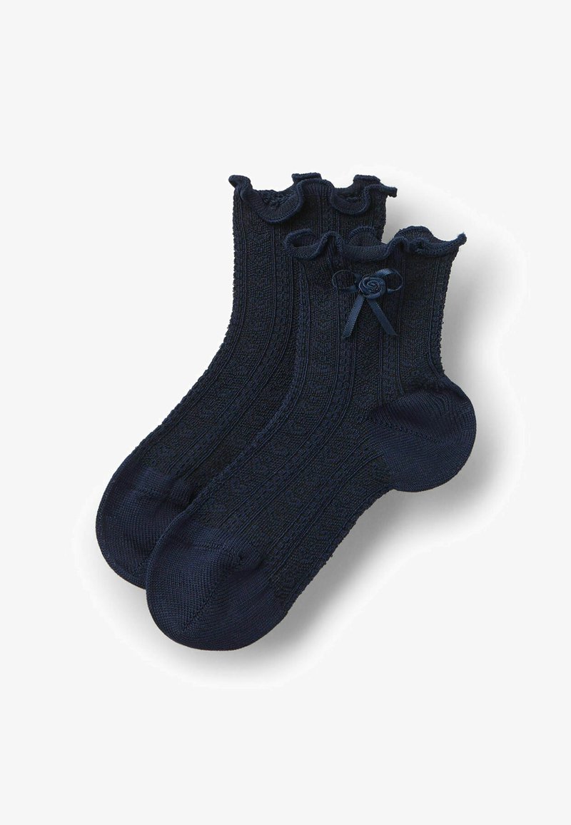 Chaussettes chevilles bleu marine avec motif tricoté texturé, poignets froncés et petit nœud décoratif sur chaque poignet.