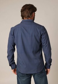Navyblauwe shirt met lange mouwen, voorzien van een geometrisch patroon, knoopsluiting en klassieke kraag, gemaakt van gladde stof.