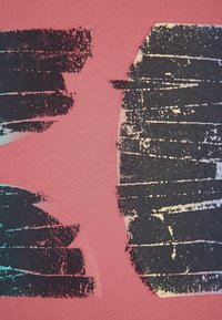 Růžová bavlněná látka s abstraktními černými a tyrkysovými štětcovými vzory; měkká textura s mírně opotřebovaným designem.