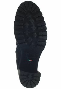 Zwarte rubberen laarzen zool met diepe profielpatronen, voorzien van kruisvormen en tekstdetails, gemarkeerd met "Made in Italy" en een Italiaanse vlag.