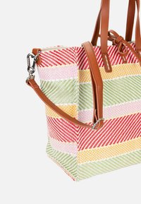 Sac fourre-tout tissé rayé avec des motifs rouges, jaunes, roses et verts, poignées en cuir marron et bandoulière amovible avec fermoirs argentés.
