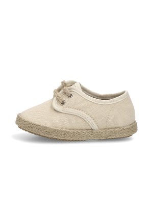 Zapato casual de lona beige con suela de yute trenzado y dos ojetes con cordones beige, exhibido sobre fondo blanco, vista lateral.