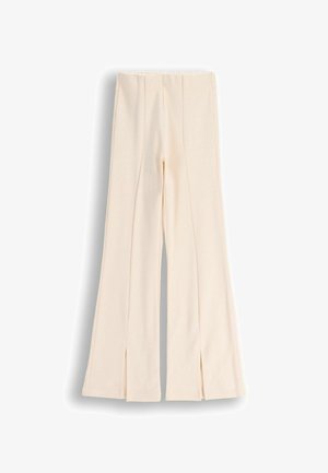 Kremowe spodnie o szerokich nogawkach z detalami szwów z przodu i małymi rozcięciami u dołu nogawek, prezentowane na białym tle.