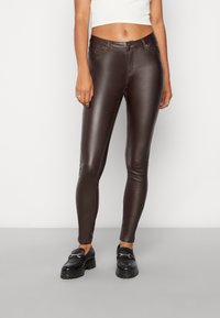 Hnědé skinny kalhoty z umělé kůže s hladkým povrchem, navržené s mírným pasem, pěti kapsami a minimem švových detailů.
