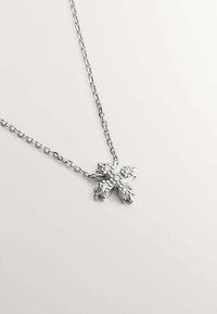 Collar de plata con un colgante de cruz, embellecido con piedras claras. La cadena presenta un diseño de eslabones clásico, con un acabado suave y pulido.