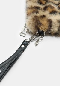 Torba od umjetnog krzna s leopard uzorkom, s crnom kožnom trakom, srebrnim hardverom i pojedinostima s patentnim zatvaračem. Teksturirana površina s mekim završetkom.