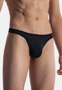 String noir en tissu doux. Présente un ajustement serr�é avec une couverture minimale et une taille élastique pour le confort.