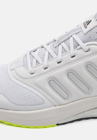 Pelēkie sporta apavi ar sietiņu augšpusi, gumijas zoli un neona zaļiem akcentiem. Ievērojama asimetriska dizaina un stratēģiska amortizācija. Viegls materiāls.