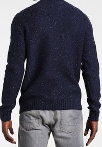 Granatowy sweter z teksturowanego dzianiny z okrągłym dekoltem i ściągaczem, z subtelnymi, wielokolorowymi drobinkami w całym materiale.