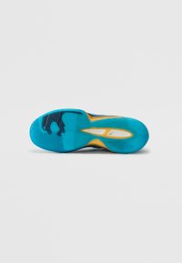 Sole in gomma blu con motivi circolari, un accento giallo e una superficie liscia. Include ritagli nella suola intermedia e un'impronta del logo stilizzata.