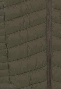 Zielona oliwkowa kamizelka puchowa z pikowanym, skośnym przeszyciem, z zapięciem na zamek i gładką, błyszczącą teksturą. Lekki materiał, casualowy styl.