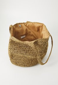 Geweven stro tote bag in een natuurlijke kleur met een zachte stoffen voering. Voorzien van een magnetische drukknoopsluiting en een klein binnenvak.