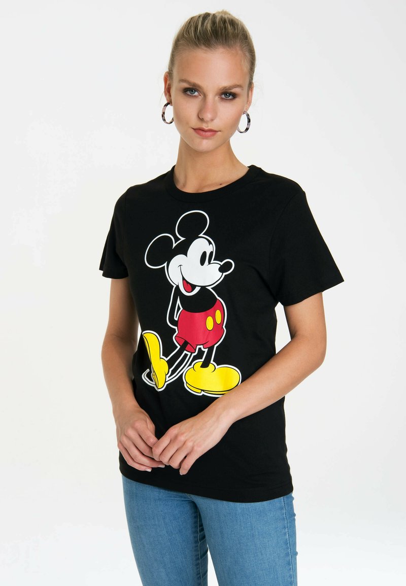 Black cotton T-shirt featuring a large, colorful graphic of Mickey Mouse in red shorts and yellow shoes. Classic crew neckline and short sleeves.