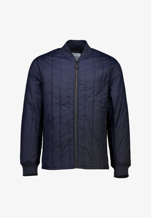 Tummansininen tikattu pommikaupungin takki, jossa on edessä vetoketju, ribbineuleet hihansuissa ja kauluksessa; ominaisuuksia on pystysuora ommelkoristelu kankaalla.