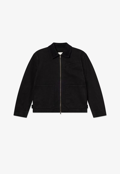 Μαύρο μπουφάν με γιακά, εμπρόσθιο φερμουάρ, δύο μεγάλες μπροστινές τσέπες και μία μικρή στο στήθος, κατασκευασμένο από ανθεκτικό ύφασμα.