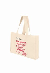 Tote bag en toile de couleur naturelle avec deux poignées, comportant un texte rouge vif : "CHÈRE ÉTÉ, S'il TE PLAÎT RESTE ENCORE UN PEU ! 28 AOÛT."