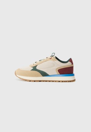 Scarpa sportiva beige realizzata con un mix di materiali, tra cui suede e mesh. Accenti in verde, marrone e blu. Suola in gomma testurizzata.