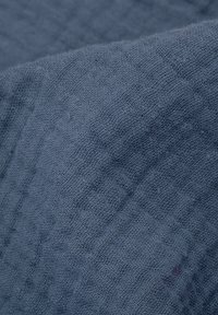 Tkactwo w miękkim, teksturowanym niebieskim materiale, z wyplecionym wzorem i lekko pomarszczoną powierzchnią, idealne do różnych zastosowań.