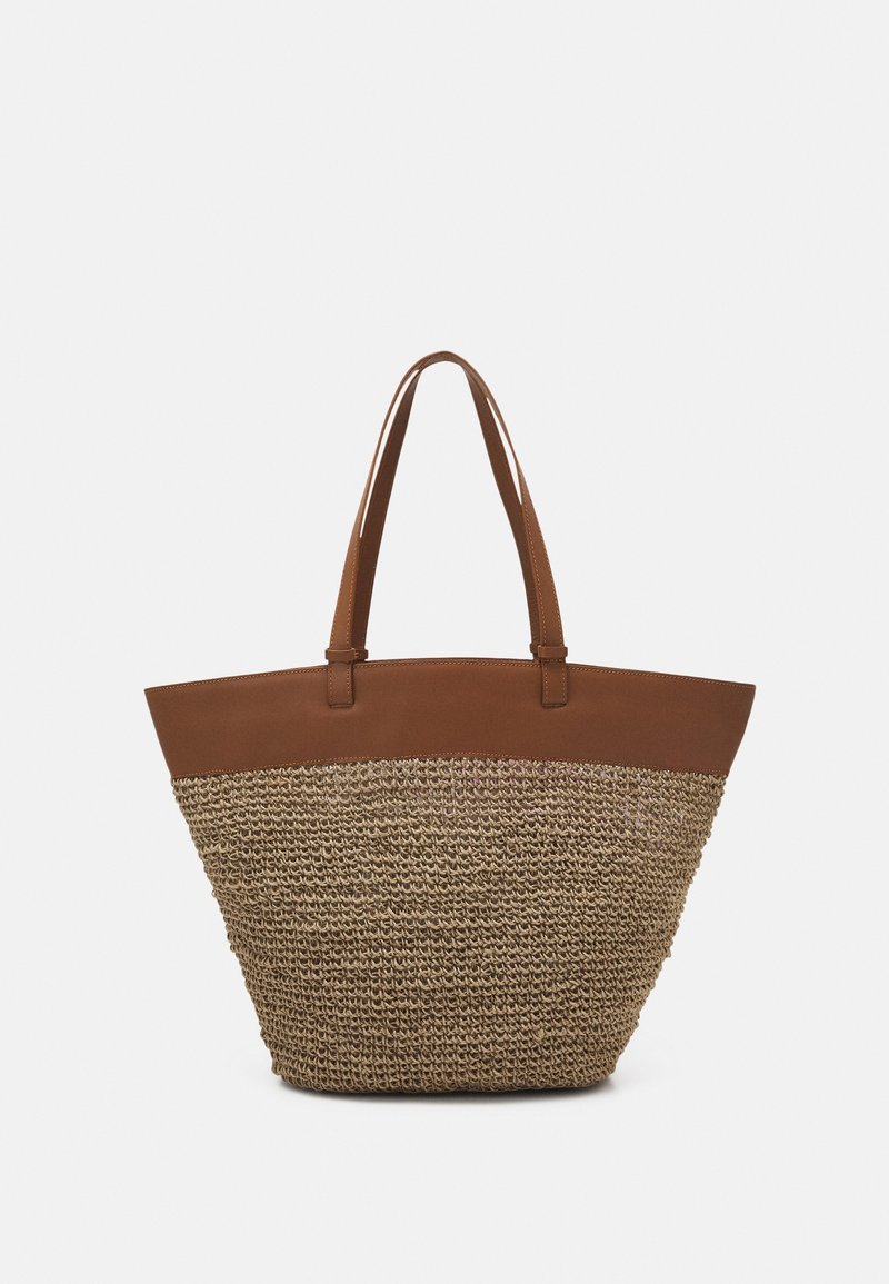 Sac cabas en paille tressée avec un panneau supérieur en cuir marron. Il présente des anses longues et plates ainsi qu'une forme large et ouverte. Le corps en paille texturé contraste avec le cuir lisse.