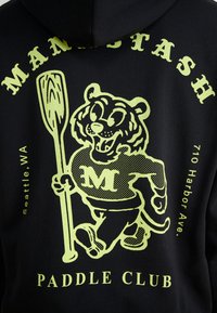 Black hoodie featuring a green graphic of a cartoon tiger holding a paddle, with "MANSTASH PADDLE CLUB" and location details printed.