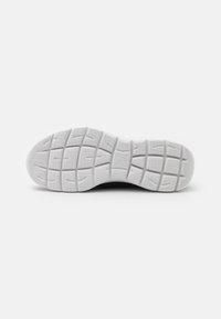 White rubber shoe sole featuring textured grip patterns and flex grooves for enhanced traction and support. Clean design, minimal detailing.