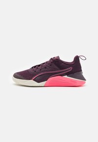 Lila Sportschuh mit Mesh-Obermaterial, kontrastierenden pinken Akzenten, Gummisohle, runder Zehenpartie und einem Ziehschlauf am Fersenbereich. PUMA-Logo sichtbar.