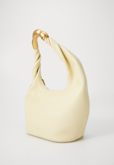 Κρέμα φούξια δερμάτινη τσάντα με στριμμένο χερούλι και χρυσές λεπτομέρειες, που διαθέτει στρογγυλό σχήμα και λεία υφή.