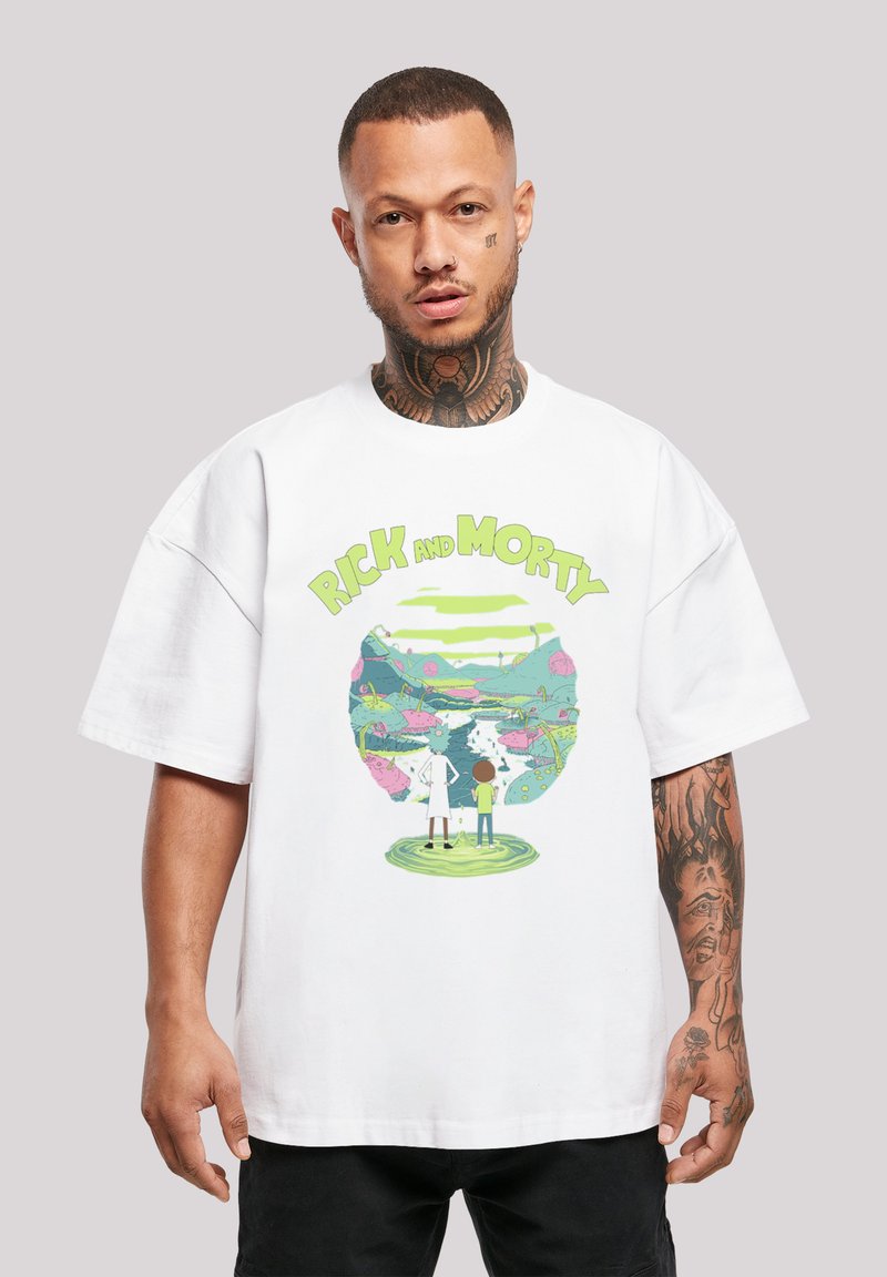 Balta kokvilnas T-kreklu ar krāsainu grafiku, kurā attēloti divi varoņi priekšā sapņainam ainavam ar tekstu "RICK AND MORTY" augšpusē.