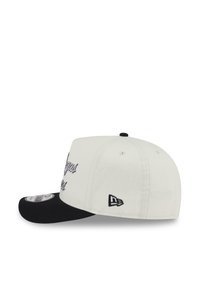 White fabric cap with black bill, featuring embroidered text and a small logo on the side. Made from durable, textured material.