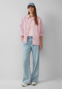 Lichtroze denim jacket, pastelroze t-shirt, lichtblauwe wijde spijkerbroeken en een blauwe pet met de tekst "love". Casual outfit met een relaxte pasvorm.