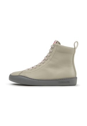 Beiger High-Top-Lederschuh mit grauer Sohle, beigen Schnürsenkeln, Zuglasche an der Ferse und seitlich geprägt mit dem „Camper“-Logo.