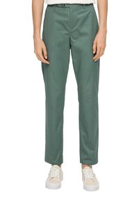 Grüne Baumwollhose mit geradem Schnitt, ausgestattet mit einem Bund mit Gürtelschlaufen und vorderen Taschen. Kombiniert mit weißen Sneakers.