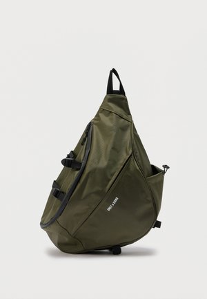 Sac à dos triangulaire olive vert avec fermeture éclair noire, sangle réglable, poche latérale et logo "ONLY SONS" à l'avant.
