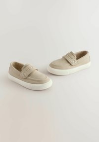 Beiga canvas slip-on skor med vit gummisula, med sömmar och två elastiska band för enkel användning.