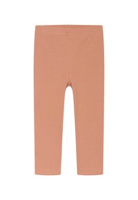 Leggins u boji breskve napravljeni su od mekog, rastezljivog materijala s elastičnom pasiom. Dizajn uključuje prilagođeni siluet i nema uzoraka ili naglasaka.