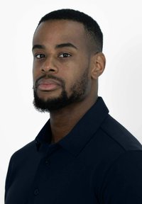 Marineblauw polo-shirt met een kraag, korte mouwen en drie knopen. Model heeft een kort geschoren baardje en kort haar, gepositioneerd tegen een witte achtergrond.