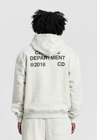 Ljusgrå hoodie med känguruficka, tillverkad av bomullsblandat tyg, med fet svart text på baksidan: "CRIME DEPARTMENT 2018 CD."